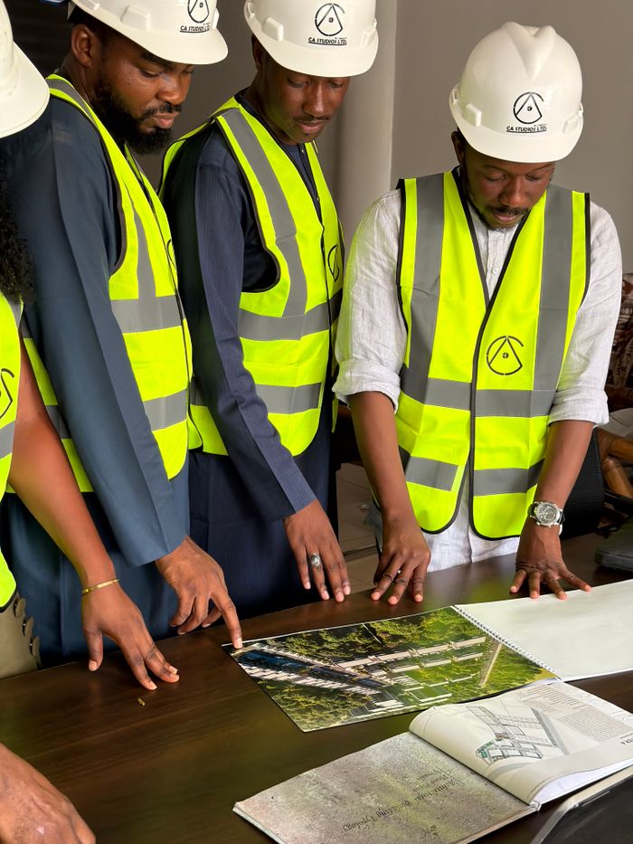 pexels photo 37198874 Group of engineers and architects examine building plans with safety gear.